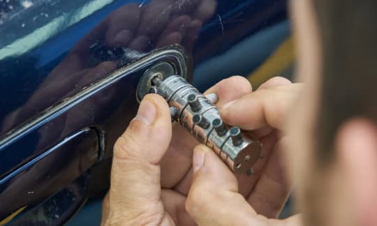 Professional locksmith unlocking a car door